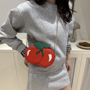 Creative red cherry shaped crossbody chain bag with green leaf detail and gold metal strap
