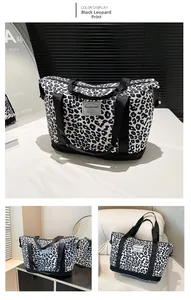 Detail showing high-capacity leopard print canvas travel bag with durable black nylon straps