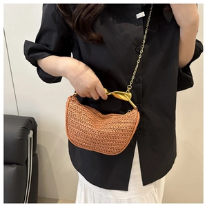 Détail d'un sac tressé orange avec poignée en métal doré et bandoulière chaîne