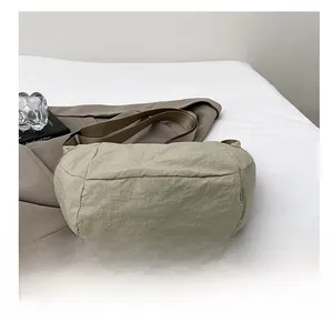 Dettaglio della borsa a tracolla kaki in nylon con trama del tessuto e base piatta