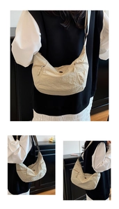 Dettaglio della borsa a mezzaluna in nylon beige con cerniere e texture con pieghe naturali