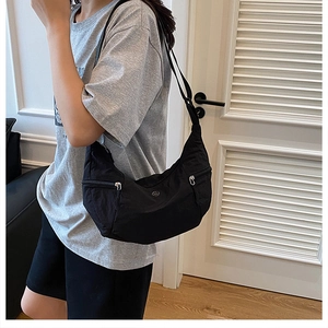 Dettaglio della borsa a tracolla in nylon nero a mezzaluna con cerniera in metallo