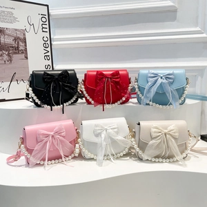 Bow design shoulder bags in six colors with pearl straps and metal chains set on a white stand