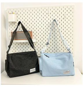 Detail of minimalist canvas crossbody bags in black and blue with adjustable straps