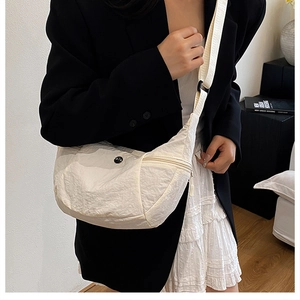 Dettaglio della borsa a tracolla bianco panna con tessuto in nylon stropicciato e tracolla