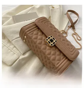 Close-up of brown quilted leather bag with gem buckle and vintage gold chain strap