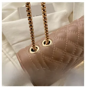 Close-up of brown quilted leather bag with elegant gold chain and stitching detail