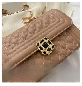 Detailed shot of brown quilted leather bag with gold square clasp and chain strap