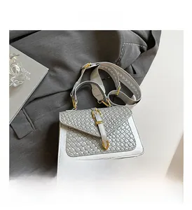 Detail of silver woven texture handbag with golden buckle and stylish fabric shoulder strap