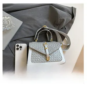 Detailed top view of grey woven crossbody bag with gold buckle and size reference