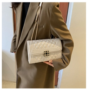 Detailed view of cream quilted leather bag with gold chain and square metal lock