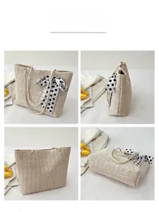 Détails du sac cabas en paille avec broderie marguerite et foulard en soie à pois au manche