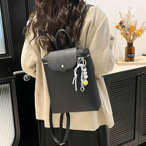 Sac à dos noir minimaliste pour femme avec rabat à paillettes et breloque cœur