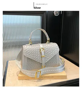 Detail of silver woven crossbody bag with gold horsebit buckle and embroidered strap