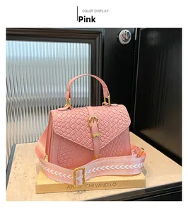 Detail of pink woven leather bag with gold buckle and jacquard patterned wide shoulder strap