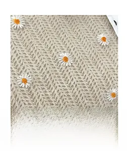 Detail of daisy embroidery on white wavy knit fabric for large straw tote bag