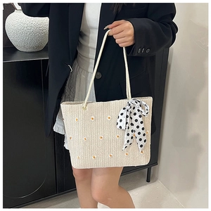 Détail du sac cabas en paille tissée avec broderie florale orange et foulard à pois