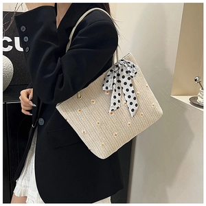 Sac cabas en paille avec broderie marguerite et foulard à pois porté par un mannequin