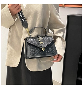 Black vintage crossbody bag with woven texture lid and patterned wide shoulder strap