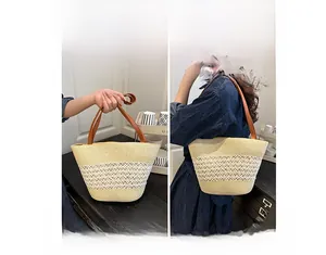 Detail der Strohtasche mit zwei Tragemöglichkeiten und Ledergriffen in Beige