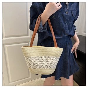 Detail of hand-woven straw tote bag with white diamond patterns and brown leather straps