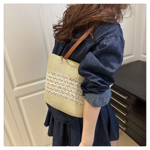 Close-up of beige woven straw shoulder bag featuring intricate diamond hollow patterns