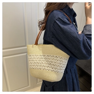Detail of color-block straw tote featuring hollow weave texture and leather straps