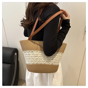 Detail of the woven tote bag showing the two-tone texture and brown faux leather straps