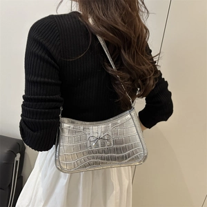 Silver crocodile embossed hobo bag with metallic bow detail and sleek crescent shape