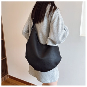 Detail of black pebbled leather hobo bag showing large capacity and soft texture