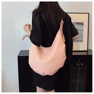 Pink lychee texture leather hobo shoulder bag shown on a model for size perspective