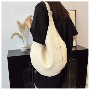 Detail view of large cream leather shoulder bag with lychee texture and silver buckle
