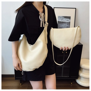 Detail of cream lychee texture leather hobo bag and matching crescent pouch for women