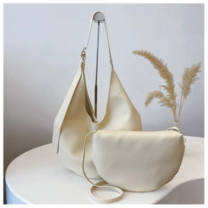 Detail of lychee pattern leather bucket bag set in creamy beige with a matching pouch