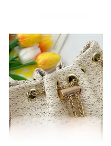 Detailed close-up of the woven texture and golden drawstring hardware on the bucket bag