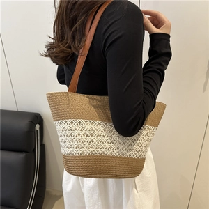 Contrast woven tote bag with brown leather straps shown on model for seaside vacation