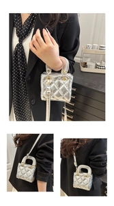 Detailed view of silver quilted leather texture and golden metal hardware on a mini handbag