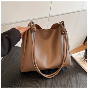 Détail d'un grand cabas vintage marron avec une bandoulière à nœud au style minimaliste