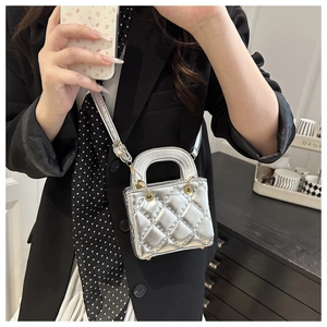 Silver quilted metallic micro crossbody bag shown worn with a black blazer