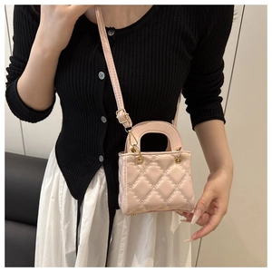 Detail of pink quilted mini crossbody bag with golden round metal handle and leather strap