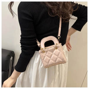 Macro shot of pink quilted leather crossbody bag with golden hardware and rhombic pattern