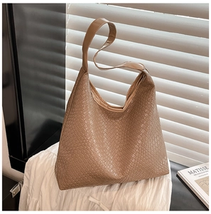 Detailed close-up of khaki woven texture and wide shoulder strap on a retro hobo tote bag