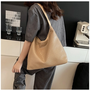 Detail of the woven texture on a large apricot tote bag for professional commuting