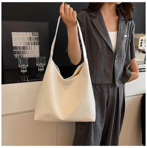 Detail of white large woven tote bag with fine lattice texture and integrated strap