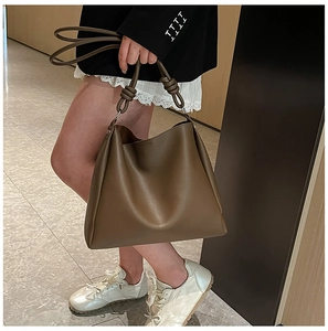 Détail de l'anse nouée et de la boucle en métal d'un sac hobo marron foncé