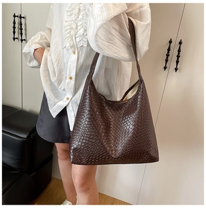 Close-up of deep brown hobo tote featuring woven texture and wide shoulder strap