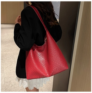 Rear view of a model carrying a large red woven tote bag for summer casual fashion