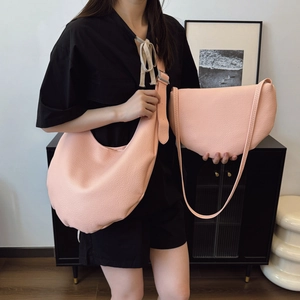 Pink lychee grain leather crescent shoulder bags in a minimalist bucket bag style