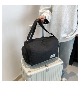 Detail of a black canvas travel bag with double zippers placed on a white suitcase