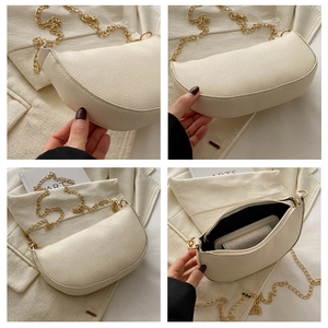 Macro shot of off-white dumpling bag showing litchi grain texture and gold chain details